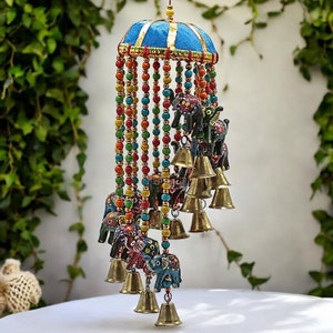 May include: A colourful wind chime with a blue and gold fabric top, featuring multiple small painted elephants and bells hanging from beaded strings.