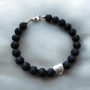 Può includere: Bracciale con perline in pietra lavica nera con un ciondolo a forma di cuore argentato con la scritta "MOM". Il bracciale ha una chiusura argentata. Le perline hanno un diametro di circa 0,8 cm.