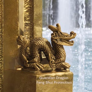 Könnte beinhalten: Eine goldene Drachenstatue mit detaillierten Schuppen und Merkmalen, vor einem Wasserfall platziert. Auf dem Sockel steht der Text "Guardian Dragon Feng Shui Protection". Der Drache ist ein Symbol für Schutz und Glück.