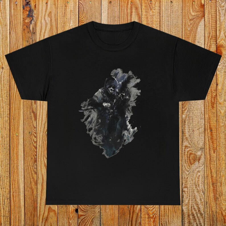 Op de afbeelding: Zwart T-shirt met een grafische print van een schaduwfiguur in een capuchon met een wapen in de hand. De figuur is omringd door een wervelend, abstract ontwerp.