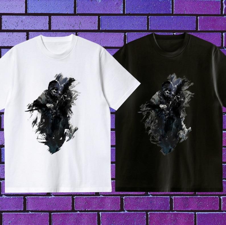 Op de afbeelding: Twee T-shirts met een grafische print van een gekapte figuur in een donkere, schaduwrijke omgeving. Een T-shirt is wit, de andere is zwart.