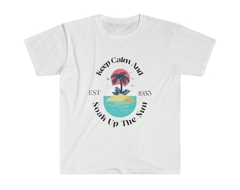 Puede incluir: Camiseta blanca con un diseño gráfico de una palmera en una isla con un sol rojo y el texto "Keep Calm And Soak Up The Sun" con "EST 1953" debajo del gráfico.