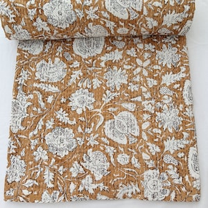 May include: A brown and white floral kantha quilt with a traditional Indian design. The quilt is made of cotton and is hand-stitched.