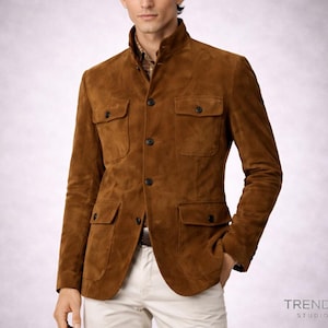 Peut inclure: Veste en daim marron avec quatre poches avant et une fermeture boutonnée. La veste a un col montant et est associée à un pantalon blanc. Le style général est classique et sophistiqué.