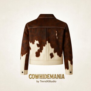 May include: A brown and white cowhide jacket with a classic collar and buttoned cuffs. The jacket features a brown upper section and a white lower section, with a cowhide pattern. The text "COWHIDEMANIA by TrendXstudio" is at the bottom.