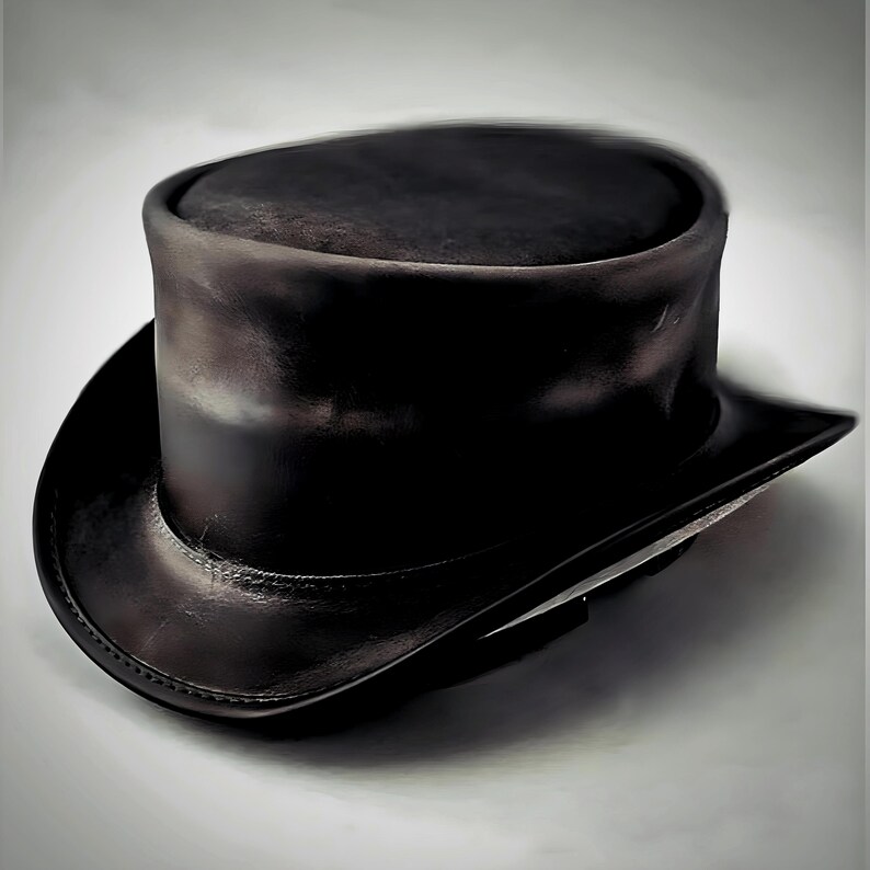 May include: A black leather top hat with a rounded crown and a wide, slightly curved brim. The hat has a classic design, with a smooth, polished finish. The hat is a formal accessory.