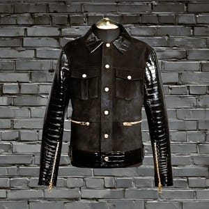 May include: A black leather jacket with gold zips and a suede front panel. The sleeves are made of a shiny, textured material.
