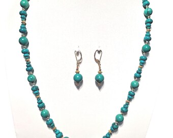 May include: A turquoise and gold necklace and earrings set. The necklace is made of round turquoise beads with gold accents. The earrings are simple gold hoops with a turquoise bead hanging from each.
