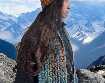 May include: A colorful crochet hat and scarf set. The hat and scarf feature a mix of blue, orange, green, and brown yarns. The hat is a beanie style, and the scarf is long and rectangular. The set is likely handmade.