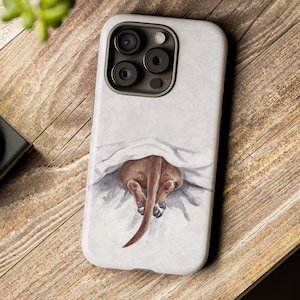 May include: A white iPhone case featuring a watercolor illustration of a brown dog's rear end peeking out from under a white blanket. The case has a glossy finish and a camera cutout. The case is on a wooden surface.