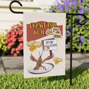 May include: A rectangular garden flag with a crawfish boil theme. The flag features text that reads "CRAWFISH BOIL" and "YOU ARE HERE." Illustrations include crawfish, potatoes, and corn. The flag also has the text "SAY NO TO POT!"