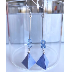 May include: A pair of silver dangle earrings with blue origami paper pyramids and blue crystal beads.