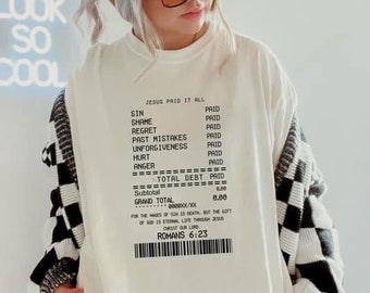 Könnte beinhalten: Weißes Sweatshirt mit einem schwarz-weißen Quittungsdesign. Die Quittung lautet "Jesus hat alles bezahlt" und listet verschiedene Sünden mit dem Wort "Bezahlt" neben jeder auf. Die Quittung enthält auch einen Gesamtbetrag von 0,00 und die Schrift Römer 6:23.