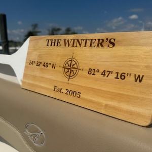 May include: A wooden sign with the text "THE WINTER'S" and coordinates "24° 32' 49" N - 81° 47' 16" W" and "Est. 2005". A compass rose is engraved in the centre of the sign.