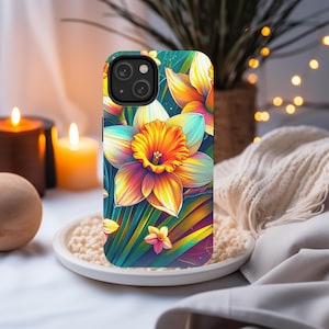 May include: A phone case with a colorful floral design featuring a large yellow daffodil with orange and red accents. The background is a vibrant green with hints of blue and purple.