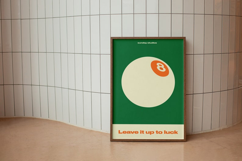 May include: A framed poster with a green background and a white 8-ball with an orange number 8. The text "Leave it up to luck" is printed below the 8-ball.