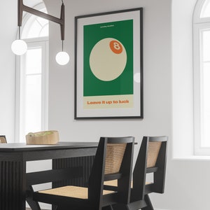 May include: A black framed poster with a green background and a white 8-ball with an orange number 8. The text "Sunday Studios" and "Leave it up to luck" are printed in white on the poster.