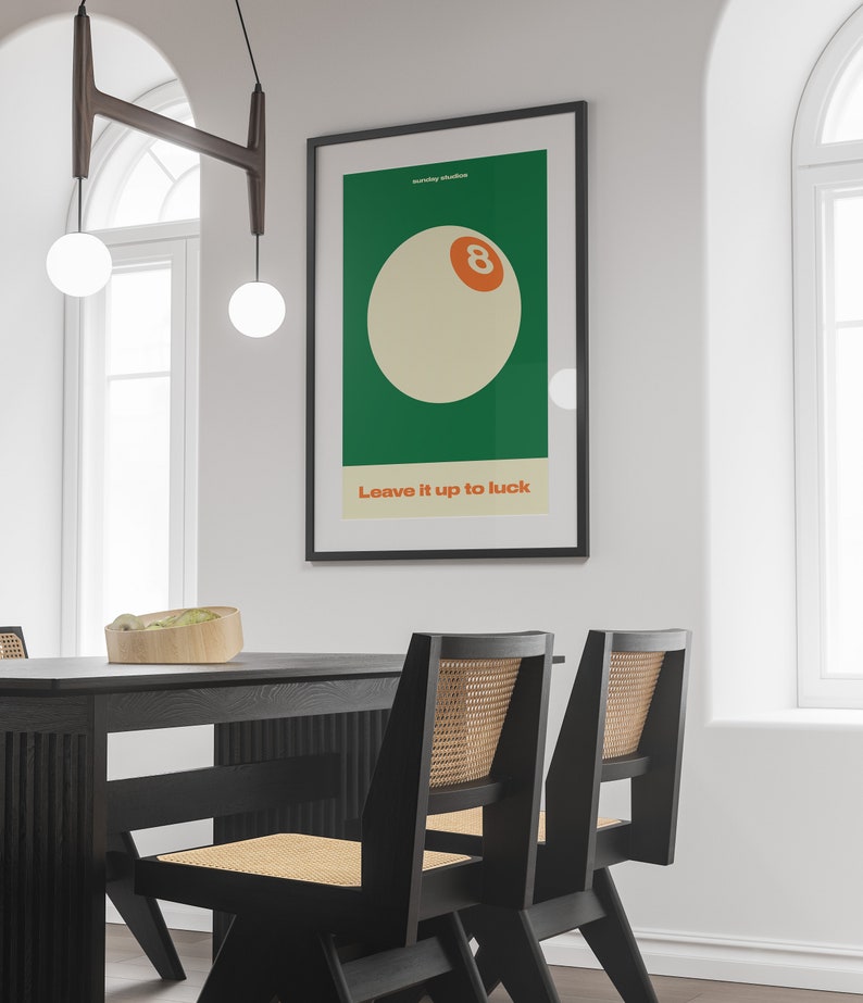 May include: A black framed poster with a green background and a white 8-ball with an orange number 8. The text "Sunday Studios" and "Leave it up to luck" are printed in white on the poster.
