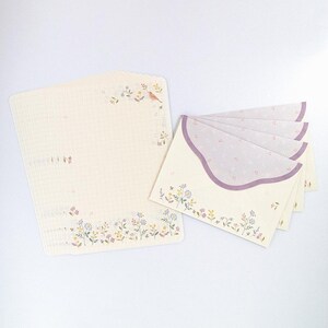 May include: A set of five white envelopes with a purple scalloped edge and a delicate floral pattern. The envelopes are lined with a light purple polka dot pattern. The set also includes a sheet of white stationery with a floral border and a small bird illustration.