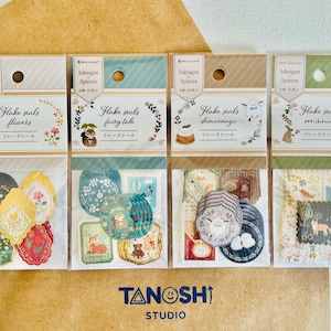 May include: Five packages of decorative paper flake seals. Each package contains 5 designs of seals with a different theme. The themes are flowers, fairy tale, shimaenaga, michidasar. The packages are white with a light blue, green, brown, or light green background. The packages have the text "Flake seals" and the theme name printed on them.