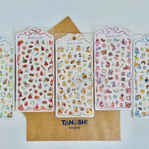 May include: Six sheets of colorful patterned stickers with Japanese text. Each sheet features a different design with various illustrations, including teacups, flowers, and pastries. The stickers are perfect for adding a touch of whimsy to journals, planners, and other craft projects.
