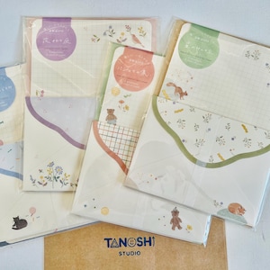 May include: Set of five colorful stationery note cards with envelopes. Each card features a different illustration of animals and nature scenes. The cards are decorated with a scalloped edge and the text "Tanoshi Studio".