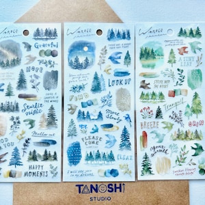 May include: Three sheets of watercolor stickers featuring forest scenes with trees, leaves, and birds. The stickers have phrases like "Graceful", "Starlit Night", "Look Up", "Tranquil", and "Good for You".