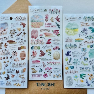 May include: Three sheets of colorful floral patterned stickers with inspirational words and phrases. The stickers feature watercolor illustrations of flowers, leaves, and birds. The words on the stickers include "Catch Some Rays", "All is Well", "You the Best", "To Be Calm", "Mindful", "Joyous", "Look", "Nature", "Happiness is a Teeable Flower", "Bright", "Glassy", "Nostalgia", "Nice Day", and "What a Wonderful Thing!"