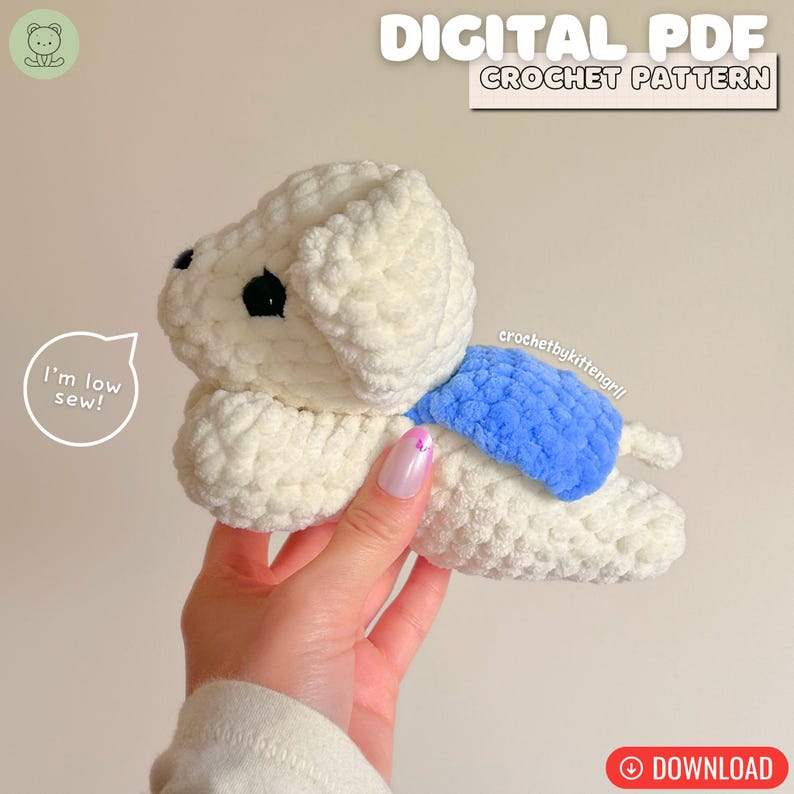 May include: A cream-coloured crocheted dog with a blue accent. The dog has black eyes and is lying down. Text at the top reads "DIGITAL PDF CROCHET PATTERN". A speech bubble says "I'm low sew!"