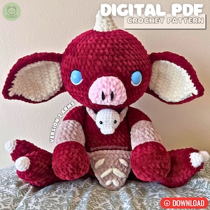 May include: A crocheted plush toy in the shape of a red and white pig with a horn. The toy has blue eyes and a pink nose. The toy is holding a smaller white crocheted toy. The image includes the text "DIGITAL PDF CROCHET PATTERN" and "VERSION 2 ARMS".