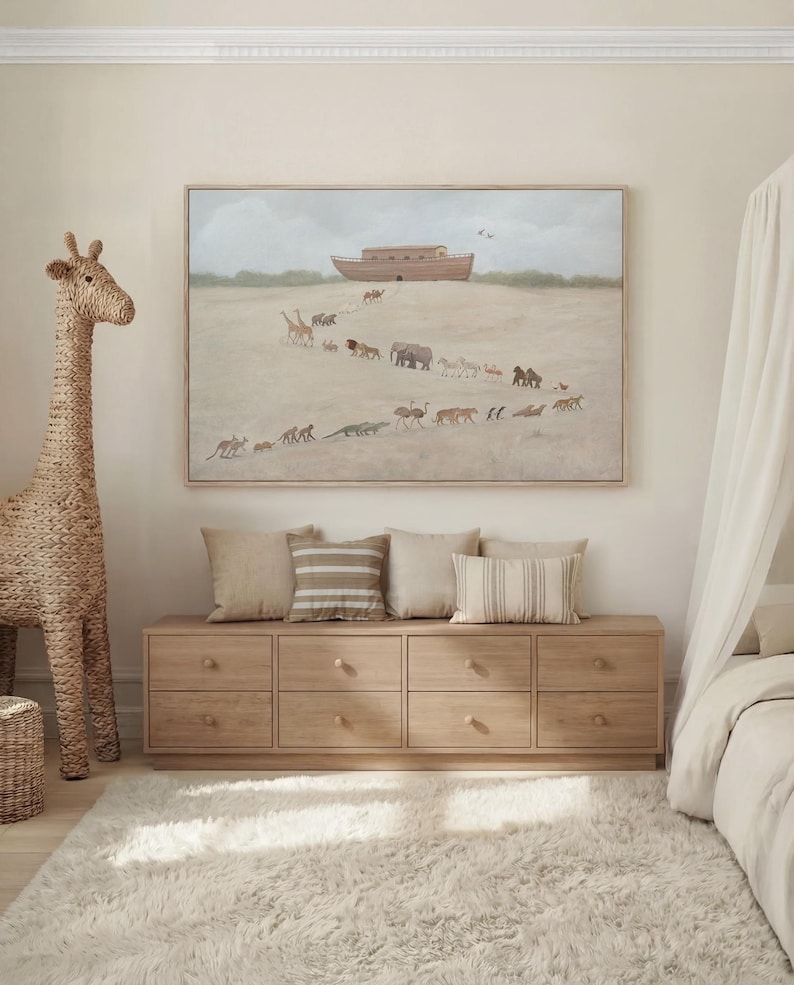 May include: A rectangular wall art print in a light wood frame depicting a large wooden ark resting on a sandy hill with a procession of various animals walking toward it. The scene features giraffes, elephants, lions, and other wildlife.