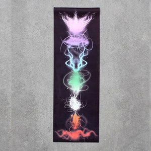 May include: A black yoga mat with a colorful illustration of the seven chakras. The chakras are represented by swirling, abstract shapes in shades of red, orange, yellow, green, blue, indigo, and violet.