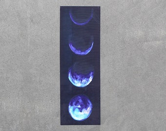 Pode incluir: Um tapete de ioga azul escuro com um design de aquarela de cinco fases da lua em tons de azul e roxo.