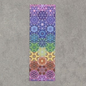 May include: A colorful yoga mat with a geometric pattern of hexagons and stars. The mat features a rainbow gradient of colors, starting with purple and ending with yellow.