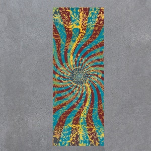 May include: A long, rectangular yoga mat with a colorful, abstract design. The design features a swirling pattern of red, blue, and yellow colors, with a central circle.