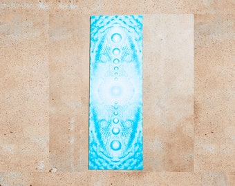 May include: A blue yoga mat with a white and blue mandala design. The design features a central circle with a series of concentric circles and dots radiating outwards.