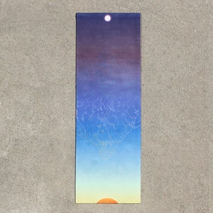 May include: A yoga mat with a mountain range design in shades of blue, purple, and yellow. The mountain range is outlined in white and a white moon is visible in the upper left corner. A yellow sun is visible in the lower right corner.