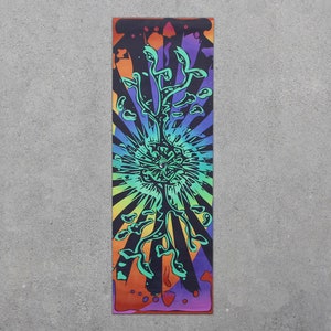 May include: A psychedelic tapestry with a colorful, abstract design featuring a tree with a large, central eye. The background is a radial pattern of stripes in shades of orange, yellow, green, blue, and purple.