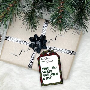 K&ouml;nnte beinhalten: Ein Weihnachtsgeschenkanh&auml;nger mit einem gr&uuml;nen, roten und wei&szlig;en Stechpalmen-Design. Der Anh&auml;nger lautet "An: John Von: Janet Vielleicht h&auml;ttest du eine Liste machen sollen."