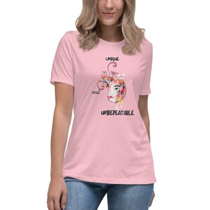 May include: A pink t-shirt with a colorful floral design and the text "UNIQUE and UNREPEATABLE" printed on the front.