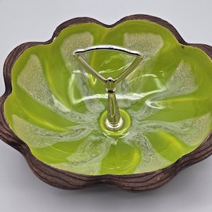 May include: A green and white ceramic serving dish with a metal handle. The dish has a scalloped edge and a swirl pattern.