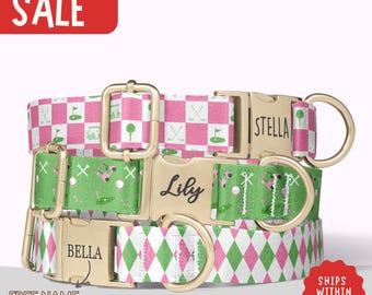 May include: Three dog collars with golf-themed patterns in pink, green, and white. The collars have gold-colored buckles and D-rings. One collar has the name "Lily" engraved, another "Stella", and the third "Bella". The word "SALE" is in a red rectangle.