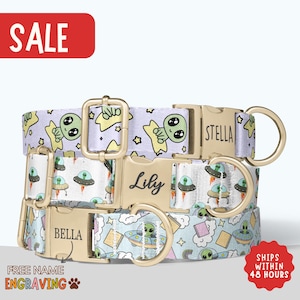 May include: Three personalized dog collars with gold-colored hardware. Each collar features a unique pattern with alien and UFO designs. The collars are light blue, white, and purple. The names "Stella", "Lily", and "Bella" are engraved on the buckles. The word "SALE" is in a red rectangle.