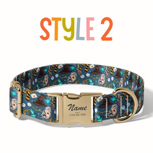 A colorful dog collar with a pattern of various cartoon-style characters and objects, including a witch's hat, broomsticks, and a castle. The collar has a gold buckle and the text "STYLE 2" is displayed above it.
