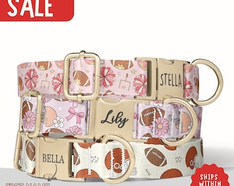 May include: Three dog collars with football and floral patterns. The collars are pink and white with gold-colored hardware. The collars have the names "Stella", "Lily", and "Bella" engraved on them. The word "SALE" is in a red rectangle.