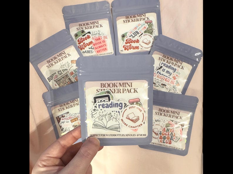 May include: Eight small clear plastic bags with colorful stickers inside. Each bag has a label that says "Book Mini Sticker Pack" and features a different book-themed design. The stickers are perfect for water bottles, Kindles, and more.