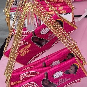 Puede incluir: Un bolso de cadena rosa y dorado con un diseño de envoltorio de cigarro Backwoods. El bolso tiene una imagen de una persona y el texto "Happy Birthday Nicole".