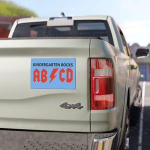 May include: A blue and red car magnet with the text "Kindergarten Rocks" and "ABC" with a lightning bolt in between the letters.