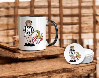 Op de afbeelding: Een witte keramische mok met een zwart handvat heeft een cartoonillustratie van een persoon die een zwart-wit gestreept shirt draagt met het woord "Newcastle" erop. De persoon plast op een rood-wit gestreept shirt met het woord "Sunderland" erop. De mok staat op een houten oppervlak.