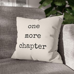 May include: A white throw pillow with black text that reads "one more chapter".